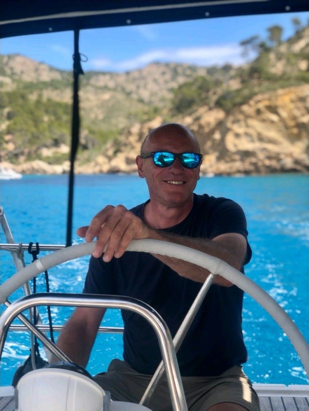 Votre skipper à la barre, dans une crique turquoise de Majorque
